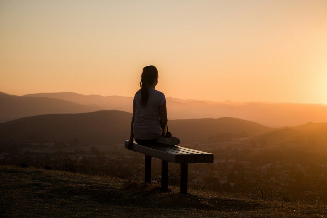 Pessoa meditando ao ar livre em um ambiente tranquilo